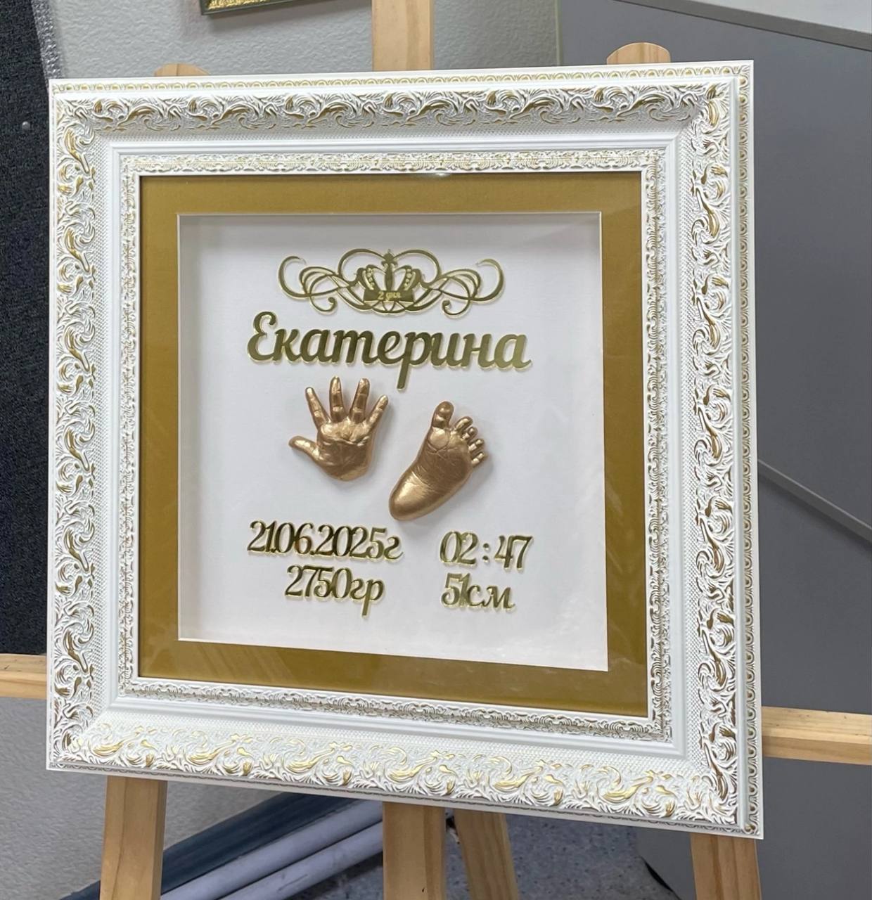 Золотые слепки в белом багете с именем и метрикой
